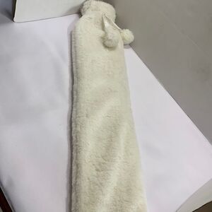 Hot water rubber bag for pain relief covered in a soft white faux fur